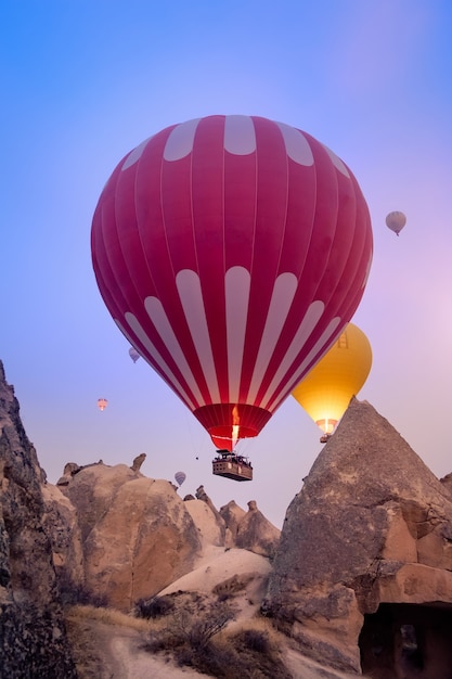 Hermosos globos aerostáticos volando sobre el paisaje de Capadocia al amanecer