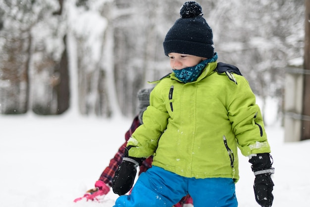 Hermosos hermanos jugando en la nieve