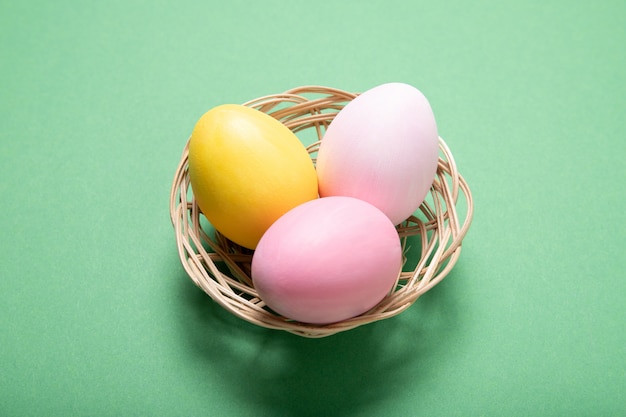 Hermosos huevos de Pascua en una cesta en un verde