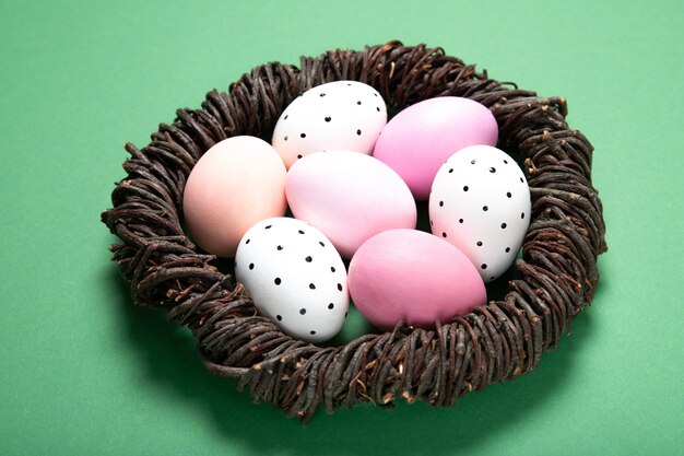 Hermosos huevos de pascua en un nido sobre un fondo verde