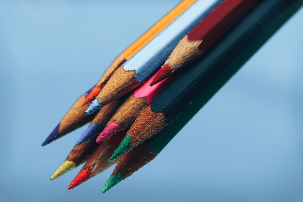 Hermosos lápices multicolores en el agua sobre un fondo azul