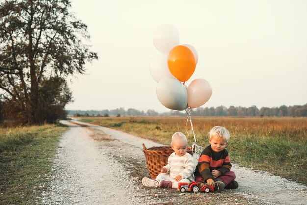 Hermosos niños felices jugando en la naturaleza Hermano y hermana en el parque de otoño Familia al aire libre