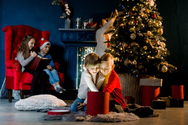 Hermosos niños pequeños miran regalo mágico