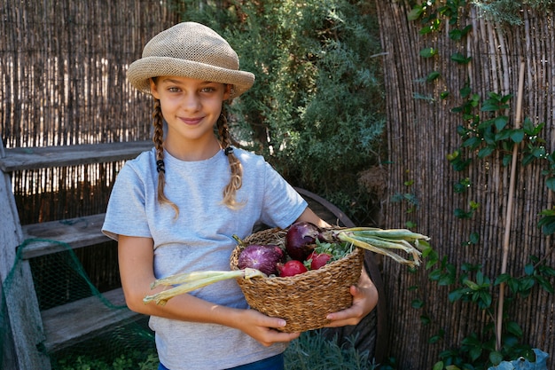 Hermosos niños rubios con cesta de verduras