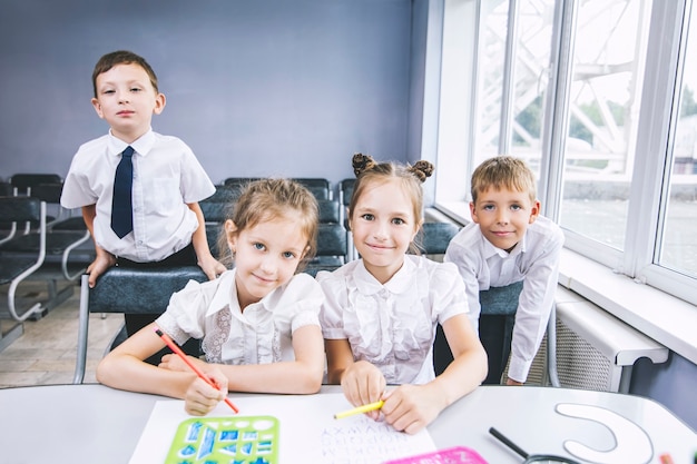 Hermosos niños son estudiantes juntos en un aula en la escuela reciben educación feliz