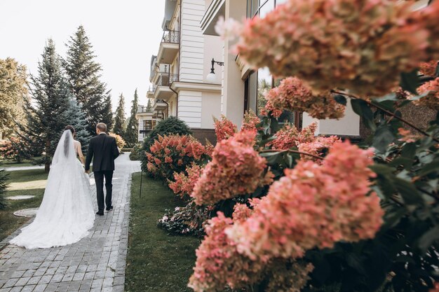 hermosos novios se abrazan en un área grande, detrás de ellos un palacio de color claro