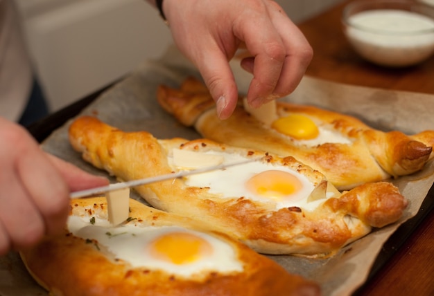 Hermosos pasteles abiertos khachapuri con huevo, cocina georgiana