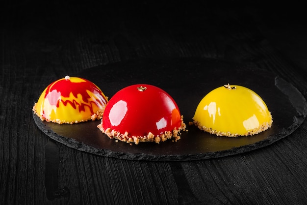 Hermosos pasteles cubiertos con postres de pastelería de diseño de concepto de esmalte rojo y amarillo brillante