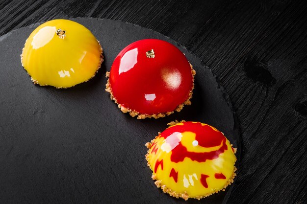 Hermosos pasteles cubiertos con postres de pastelería de diseño de concepto de esmalte rojo y amarillo brillante