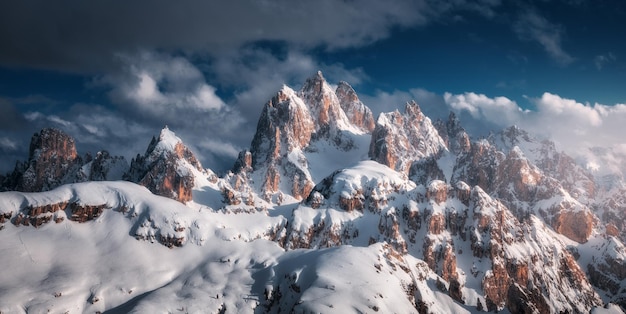 Hermosos picos de montaña en la nieve en invierno al atardecer Paisaje dramático con altas rocas nevadas en niebla cielo azul con nubes en la noche fría Tre Cime en Dolomitas Italia Montañas alpinas Naturaleza