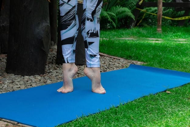 hermosos pies haciendo ejercicio en una alfombra en la hierba