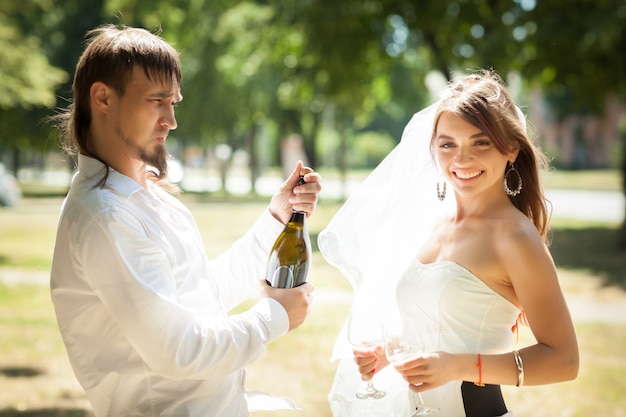 Hermosos recién casados celebrando la boda en el parque