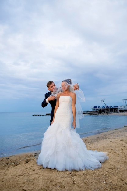 Hermosos recién casados a la orilla del mar.