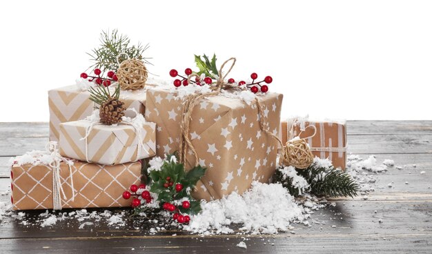 Hermosos regalos de Navidad en la mesa de madera contra la superficie blanca