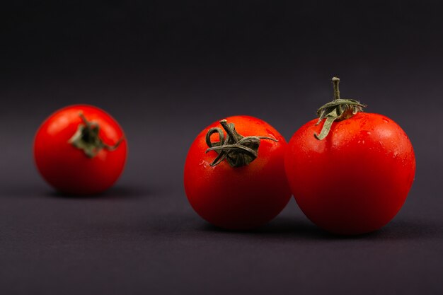 Hermosos tomates sobre un fondo oscuro