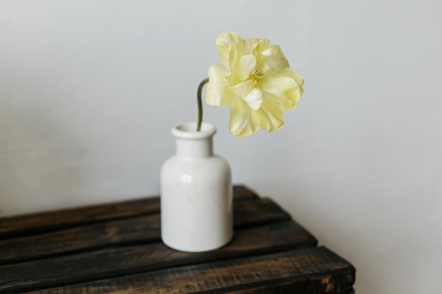 Hermosos tulipanes amarillos en un banco de madera envejecido sobre el fondo de una pared gris Flor de primavera en jarrón naturaleza rústica papel tapiz floral Feliz día de la madre Espacio de copia
