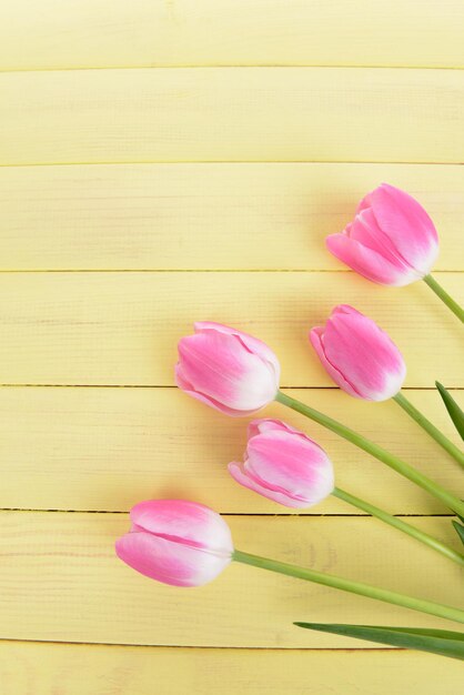 Hermosos tulipanes en balde en primer plano de la mesa