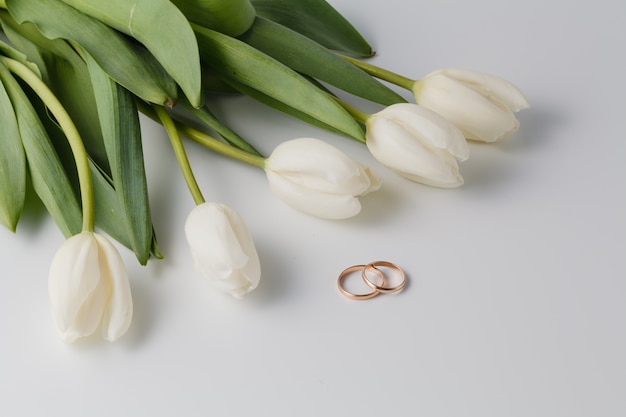 Hermosos tulipanes blancos y anillos de boda