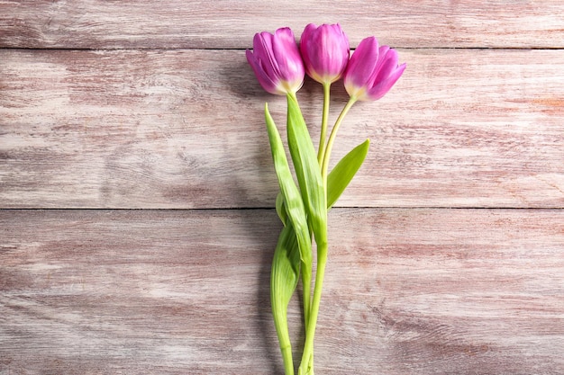 Hermosos tulipanes lilas sobre fondo de madera