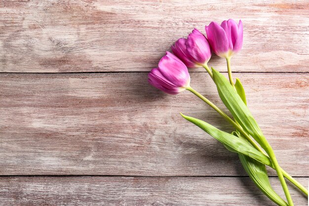 Hermosos tulipanes lilas sobre fondo de madera