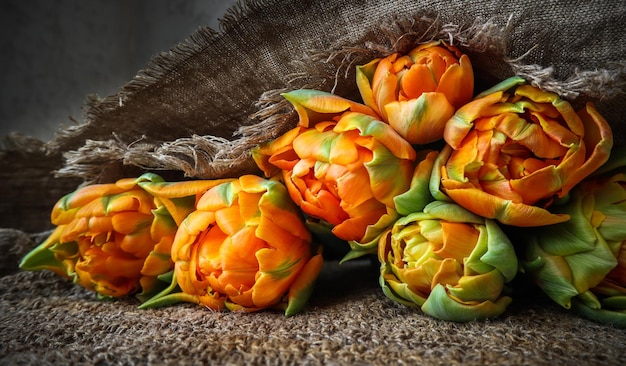 Hermosos tulipanes naranjas con una servilleta de lino