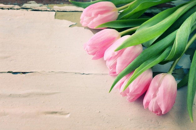 Hermosos tulipanes rosas sobre fondo de madera