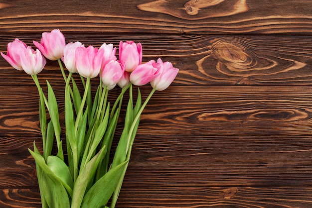 Hermosos tulipanes sobre fondo blanco de madera