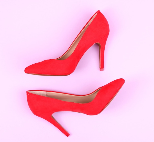 Hermosos zapatos femeninos rojos sobre fondo púrpura