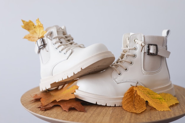 Hermosos zapatos de otoño con hojas amarillas sobre un fondo blanco.Lugar para el texto