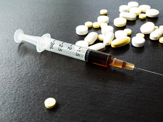 Foto heroin betäubungsmittel in nadeln mit pillenbehandlung kokain sucher drogen geschwindigkeit in spritzen verbrechen missbrauch kokain amphetamin flüssigstoff medizinische geschwindigkeit gebrauch überdosierung problem kranker junkie schlechte gefahr