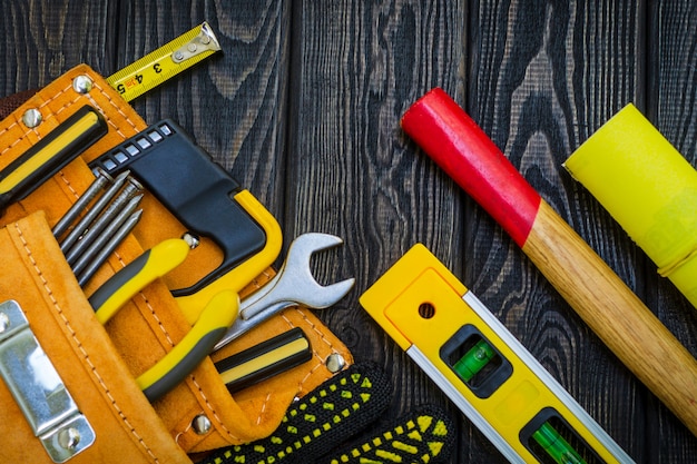 Foto herramienta en bolsa para carpintería y accesorios en tableros negros de madera