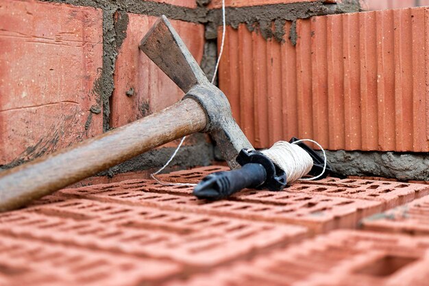 Herramienta de construcción para colocar ladrillos y bloques Herramientas de albañil martillo espátula guantes de paleta Herramientas de mano en el fondo de albañilería