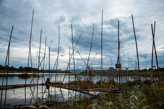 Herramienta de pesca tradicional o trampa de peces de bambú en la silueta del paisaje de la luz del atardecer