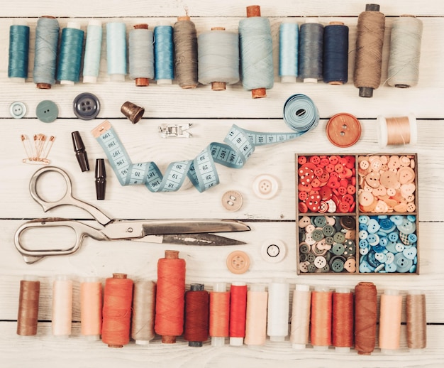 Herramientas y accesorios para coser sobre fondo de madera clara Tono vintage Vista superior