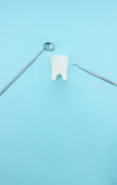 Foto herramientas básicas de dentista con modelo de diente molar en fondo azul herramientas de equipo saludable cuidado dental odontología foto conceptual implante ortodoncia