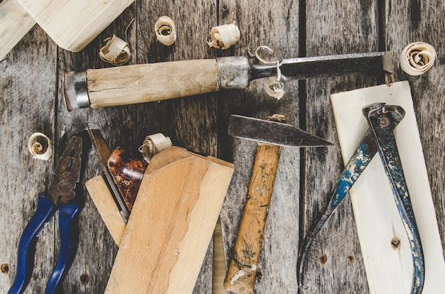 Foto las herramientas de carpintero en banco de madera, plano, cincel, mazo, cinta métrica, martillo, tenazas, alicates