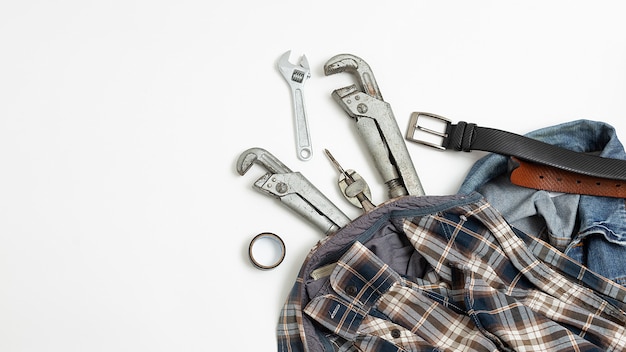 Herramientas cerca de camisa a cuadros, jeans, vista superior del cinturón de cuero. afición masculina aplanada