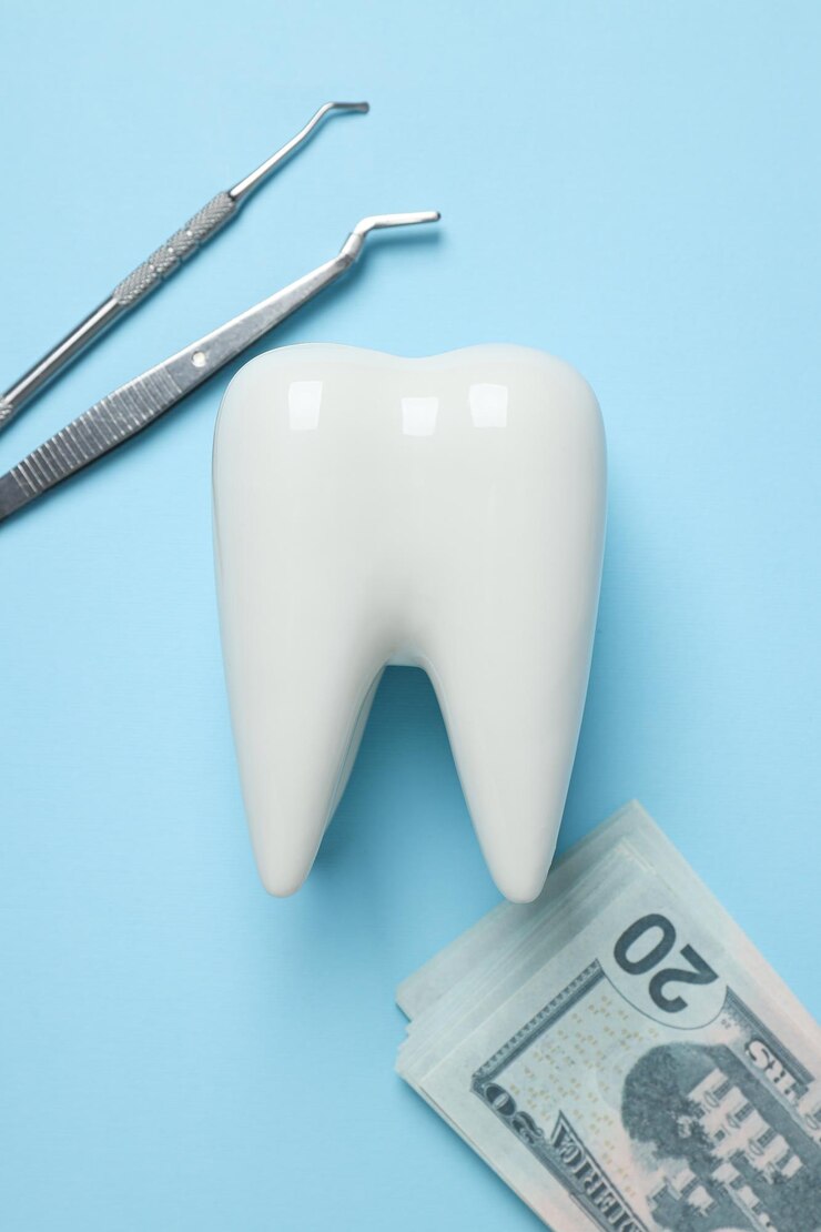 Herramientas dentales dientes decorativos y dinero en la vista superior de fondo azul