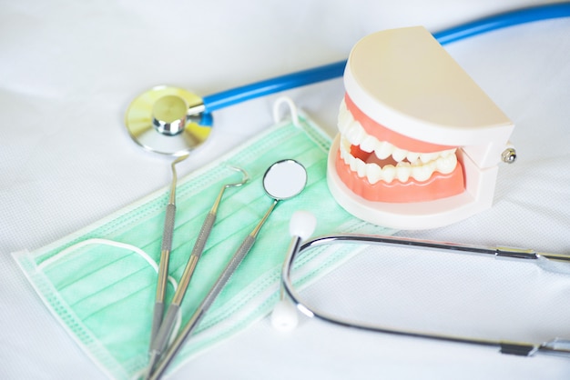 Herramientas de dentista con cepillo de dientes de bambú dentaduras postizas instrumentos de odontología y chequeo de higienista dental con modelo de dientes y espejo bucal salud bucal