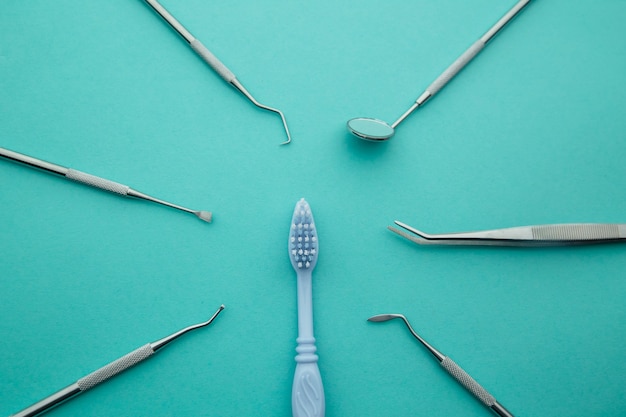 Herramientas de dentista. Instrumentos dentales profesionales de acero con espejo en azul claro.