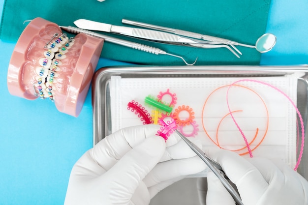 Herramientas de dentista y modelo de ortodoncia en el fondo azul, plano, vista superior.