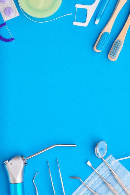 Foto herramientas de dentista sobre vista superior de fondo azul