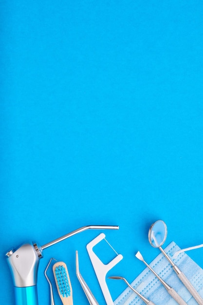 Foto herramientas de dentista sobre vista superior de fondo azul