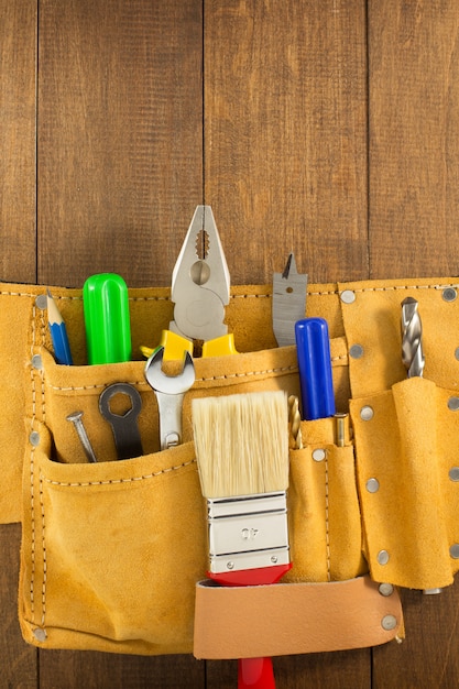 Herramientas e instrumentos en cinturon sobre madera