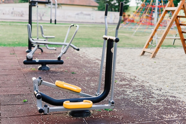 Herramientas de ejercicio en el parque público. Familia y tiempo de relax en concepto de vacaciones.