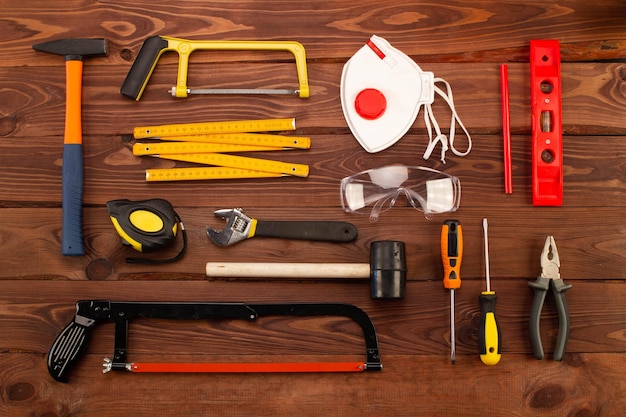 Foto herramientas y equipos de construcción en hermoso fondo de tablones de madera marrón mano de reparación básica del hogar