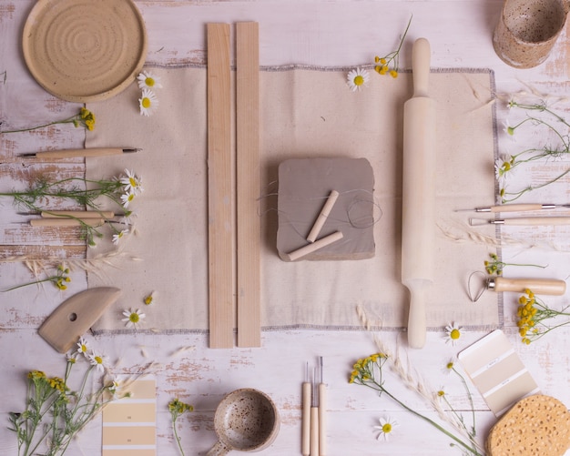 Herramientas para hacer cerámica en una mesa de madera.