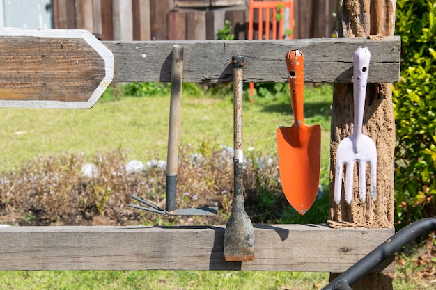Foto herramientas de jardinería colgar en riel de madera