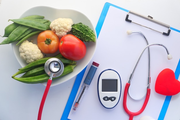 Herramientas de medición para diabéticos y verduras frescas en la mesa