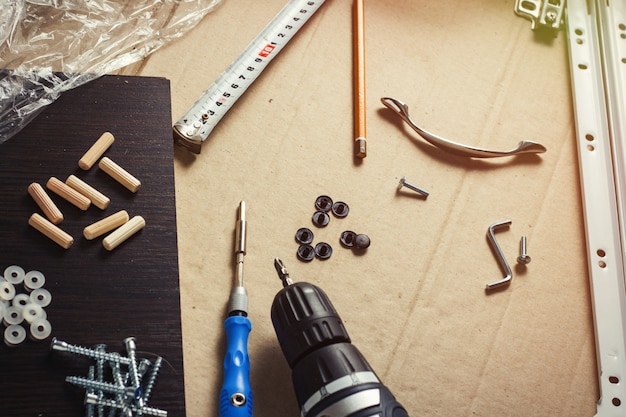 Herramientas para el montaje de muebles, Detalles de muebles, película de envoltura, Tornillos en una hoja de cartón. Taller de concepto